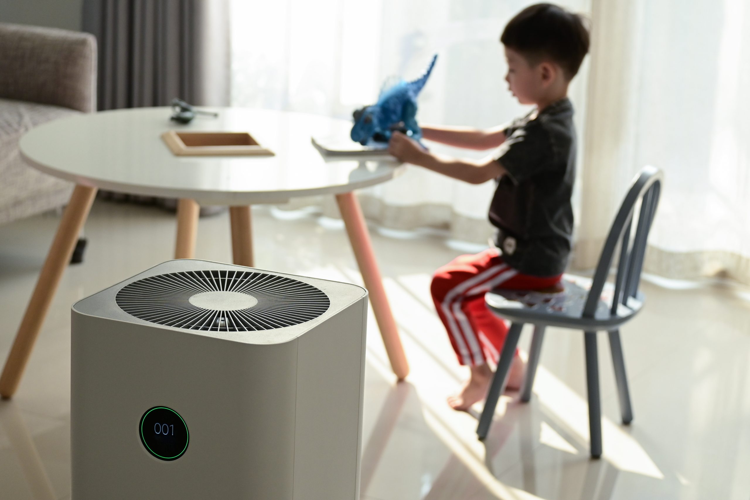 Humidifiers and dehumidifiers with kid playing in room